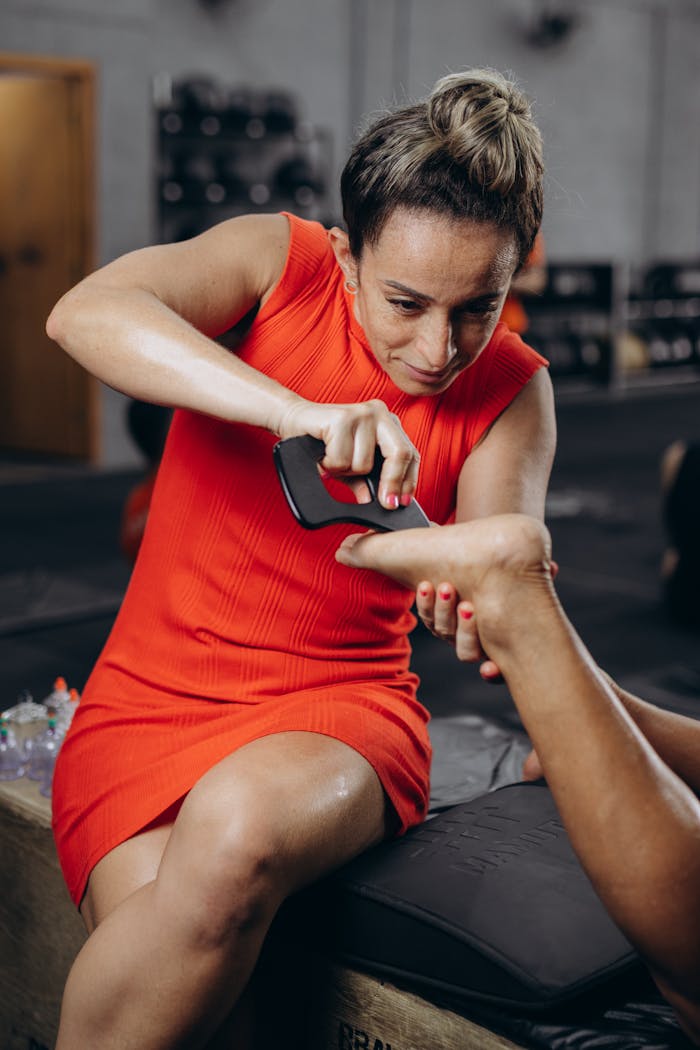 Woman Massaging Foot of Other Person at Gym
