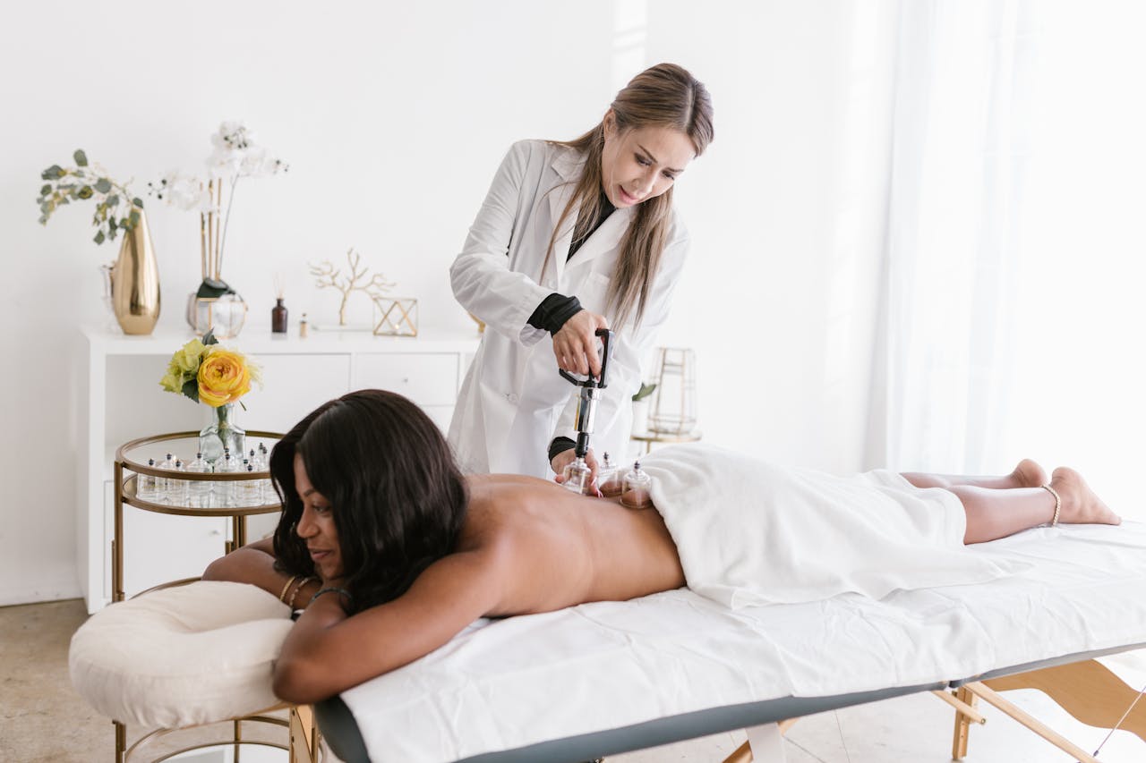 A therapist applies cupping therapy to a woman in a serene, modern wellness studio.